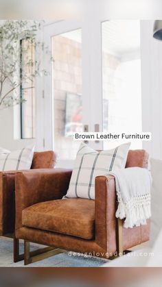 a brown leather chair sitting in front of a window next to a potted plant