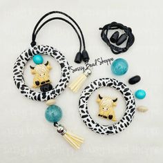 two necklaces with charms and beads are shown on a white surface, one has a cow head