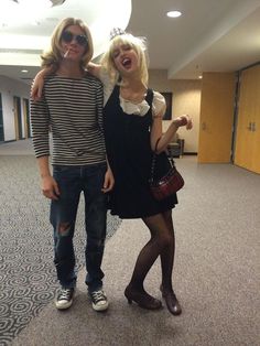 two people standing in an office building posing for a photo with one woman's hand on her shoulder