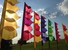 many colorful flags blowing in the wind on a sunny day