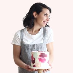 a woman holding a cake with red flowers on it