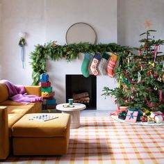 a living room decorated for christmas with stockings on the fireplace