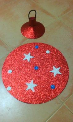 a red and white rug with stars on it next to a small candle holder in the floor