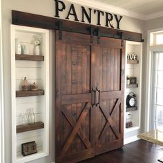 an open barn door with the word pantry on it's side and shelves below