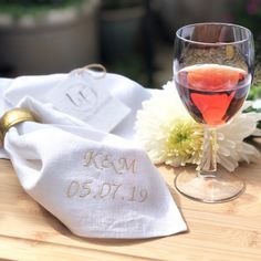 a glass of red wine on a table next to a napkin with the word kem written on it