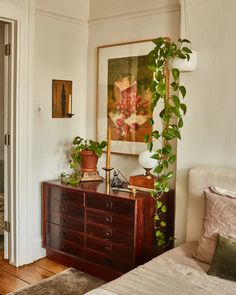 a bedroom with a bed, dresser and painting on the wall