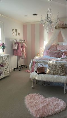 a pink and white girls'bedroom with chandelier hanging from the ceiling, rugs on the floor