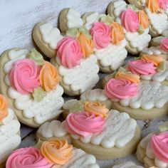 several decorated cookies with pink, orange and white frosting are on a table next to each other