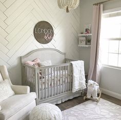 a baby's room with a crib, chair and rug