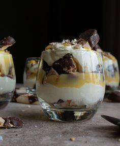 three desserts in small glasses on a table