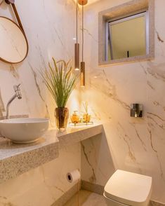 a white toilet sitting next to a sink in a bathroom under a mirror above it