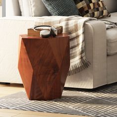 a wooden table sitting on top of a hard wood floor next to a white couch