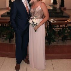 a man in a suit and tie standing next to a woman wearing a dress with sequins on it