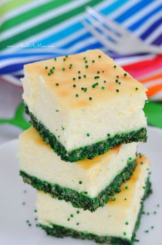 three pieces of cake sitting on top of a white plate with green sprinkles