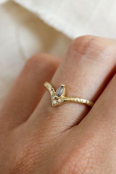 a woman's hand with a gold ring on it and a diamond in the middle