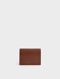 The classic snap-button wallet gets a sophisticated revamp thanks to an exquisite chocolate-brown finish. It is compact enough to slip into your daily tote and yet spacious enough to keep your cards and cash secure without any extra bulk. Carry this gem with the detachable chain strap on lunch dates and coffee runs to show it off. Charles And Keith Wallet, Brown Wallet, Short Wallet, Mini Short, Charles Keith, Chocolate Brown, Chain Strap, Snap Button, Dates