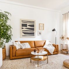 a living room filled with furniture and a painting on the wall above it's coffee table