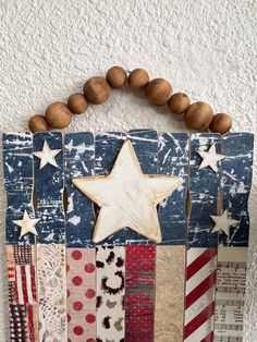 an american flag made out of wood and some beads on the string, with a star hanging from it