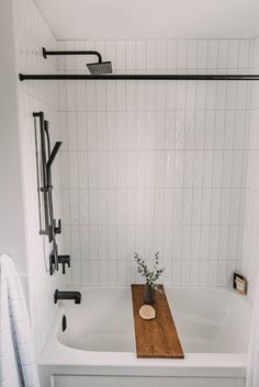 a white bath tub sitting next to a wooden cutting board on top of a sink