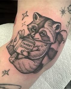 a raccoon holding a book on its leg with stars around it and the words library down below