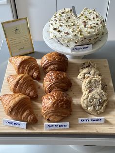 there are many different types of pastries on the table together, including croissants and cookies