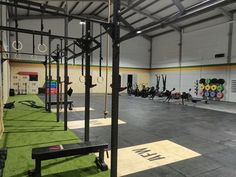 an indoor gym with rows of exercise equipment and green carpeted flooring in the background