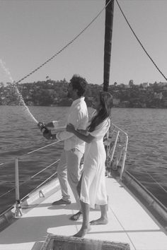 black and white photograph of two people on a boat in the water, one holding a bottle