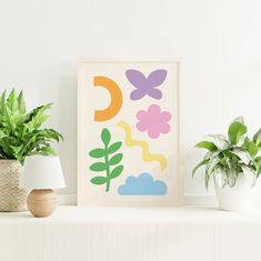 some plants are sitting on a shelf in front of a framed art print with the letter c