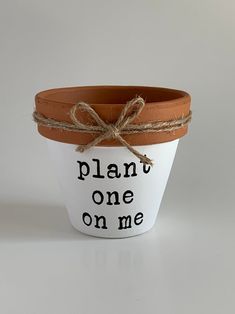 a plant pot with a rope tied around it that says, plant one on me