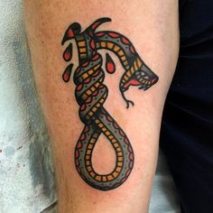 a tattoo on the leg of a person with a snake in it's tail