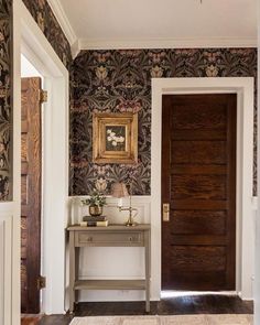 an entryway with wallpaper and wooden door