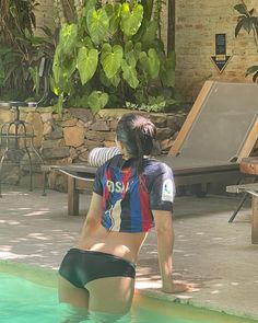 a woman standing next to a swimming pool