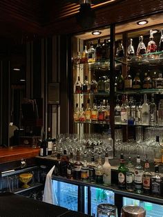 the bar is stocked with many different types of liquors and glasses on it's shelves