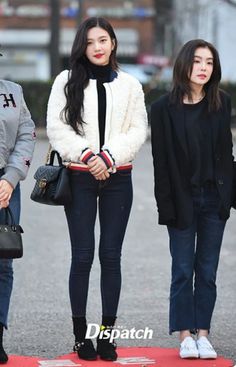 three young women are walking down the street