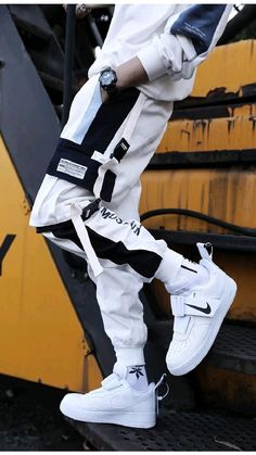 a man in white and black is standing on the back of a yellow truck with his feet up