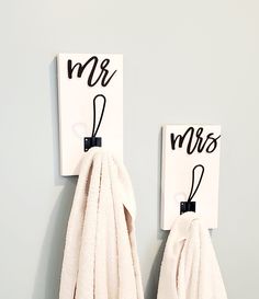 two towels hanging on the wall with mr and mrs signs attached to each towel holder