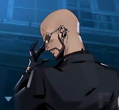 a bald man with glasses and a black jacket is standing in front of a building