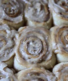 cinnamon rolls with icing sitting on top of each other