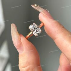 a woman's hand holding an engagement ring with a diamond in the middle and a gold band around it