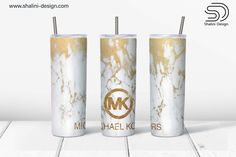 three white and gold tumblers sitting on top of a table