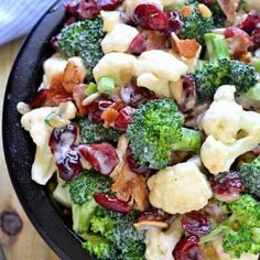 broccoli and cranberry salad in a black bowl on a wooden table