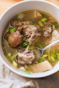 a close up of a bowl of soup with meat and veggies in it