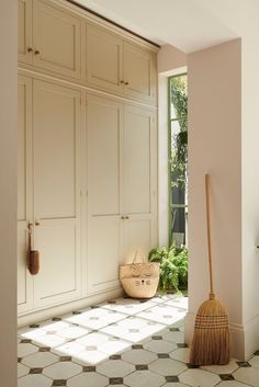 a broom sits on the floor in front of some cabinets and cupboards with windows