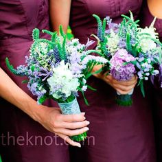 the bridesmaids are holding their purple and white bouquets