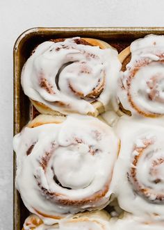 glazed cinnamon rolls with icing in a baking pan