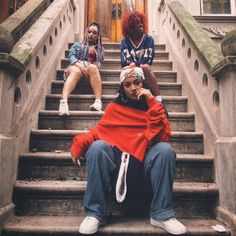 two women sitting on the steps of a building