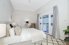 a bedroom with white walls and carpeted flooring next to a sliding glass door