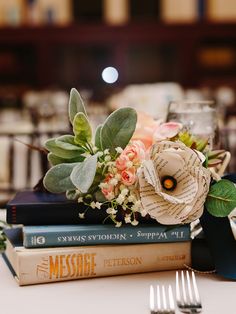 a stack of books sitting on top of a table next to a fork and knife