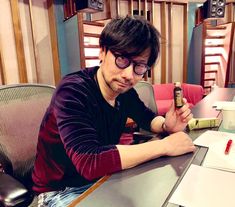 a man sitting at a table with a beer in his hand