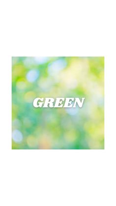 the word green is displayed in front of a blurry background with trees and grass